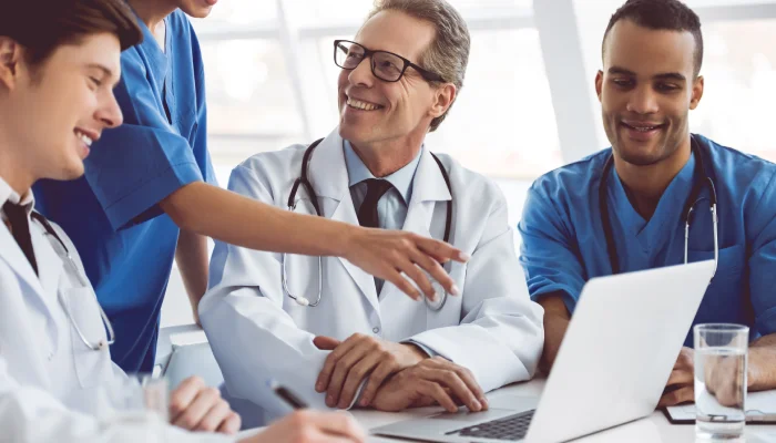 smiling doctors looking at a computer smiling doctors looking at a computer